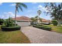 Beautiful home featuring a brick driveway, manicured shrubs, and a well-maintained lawn at 6955 Stetson Street Cir, Sarasota, FL 34243