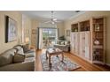 Cozy living room with hardwood floors, a ceiling fan, and sliding glass doors leading to the patio at 6955 Stetson Street Cir, Sarasota, FL 34243