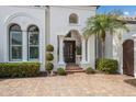 Inviting front entrance showcasing an arched entryway, decorative shrubs, and brick walkway at 7210 Desert Ridge Gln, Lakewood Ranch, FL 34202