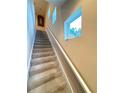 Carpeted stairway featuring a large window allowing ample natural light at 1102 Jonah Dr # 1102, North Port, FL 34289