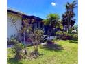 Backyard view featuring a screened porch, tropical landscaping and a clear blue sky at 1428 Pine Island Ct, Punta Gorda, FL 33950
