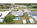 Aerial view showcasing a backyard pool, adjacent to a house with mature trees and ample yard space at 1582 Overbrook Rd, Englewood, FL 34223