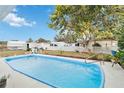 Inviting in-ground pool surrounded by a concrete deck and lush landscaping in a fenced backyard at 1582 Overbrook Rd, Englewood, FL 34223