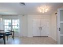 Bright entryway features neutral tile flooring, a modern light fixture, and double doors at 2466 Breakwater Cir, Sarasota, FL 34231