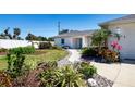 Beautifully landscaped front yard with a lush lawn, vibrant flowers, and a charming walkway leading to the entrance at 2466 Breakwater Cir, Sarasota, FL 34231