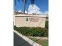 Welcoming entrance to Pinewood Village featuring lush landscaping and clear signage, creating an inviting first impression at 2763 Woodgate Ln # 208, Sarasota, FL 34231