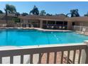 A serene view of the community pool with lounge chairs, tables, and well-maintained fencing at 2763 Woodgate Ln # 208, Sarasota, FL 34231
