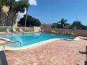 Inviting community pool featuring clear water, lounge areas, and well-kept brick pool deck at 2763 Woodgate Ln # 208, Sarasota, FL 34231
