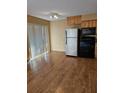 Bright kitchen featuring stainless steel refrigerator, black oven, wood cabinets, granite countertops, and sliding glass door at 2915 Lexington St # 16, Sarasota, FL 34231