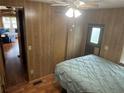 Comfortable bedroom featuring a closet, wood paneling, and laminate floors at 3333 26Th E Ave # 1025, Bradenton, FL 34208