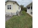 Side view of the cozy yellow home surrounded by green grass and landscaping at 3333 26Th E Ave # 1025, Bradenton, FL 34208