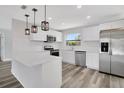 Bright kitchen features stainless steel appliances, white cabinets, and stylish pendant lighting at 3389 Dunbar St, Port Charlotte, FL 33948
