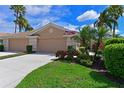 Charming home with a well-manicured lawn, lush landscaping, and a welcoming double garage at 379 Fairway Isles Ln, Bradenton, FL 34212