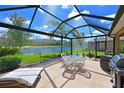 Spacious screened lanai with dining and lounge seating, along with pond and golf course views at 379 Fairway Isles Ln, Bradenton, FL 34212