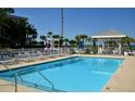 Sparkling pool area featuring chairs, tables, and shady gazebos for relaxing at 5581 Gulf Of Mexico Dr, Longboat Key, FL 34228