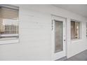 Condo unit featuring front entrance door, white walls, and windows with blinds at 5907 Garden Ln # H26, Bradenton, FL 34207
