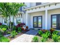 Inviting entryway with a stone walkway, a beautifully landscaped garden and a covered front porch at 6013 White Mangrove Ln, Bradenton, FL 34210