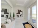 Bright entryway with a mirrored wall, sleek tiled floor, modern art and a bench with pillows at 6013 White Mangrove Ln, Bradenton, FL 34210