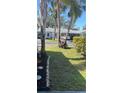 Lush condo front yard featuring mature palm trees and landscaping at 6032 Arlene Way, Bradenton, FL 34207