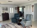 Bright and airy living room with comfortable armchairs, a vintage desk, and a view into the connected rooms at 604 Dundee Ln, Holmes Beach, FL 34217