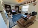 Relaxing living room with a plush blue rug, dark wood shelving, and a comfortable recliner for lounging at 604 Dundee Ln, Holmes Beach, FL 34217