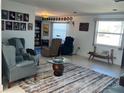 Inviting living room featuring comfortable seating, a decorative rug, and ample natural light from large windows at 604 Dundee Ln, Holmes Beach, FL 34217