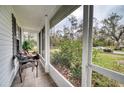 Relaxing screened front porch with comfortable seating and lush greenery for outdoor enjoyment at 7067 Jarvis Rd, Sarasota, FL 34241