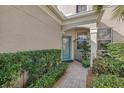 Inviting front entrance featuring a turquoise glass door, wrought iron gate, and neatly trimmed shrubs at 7416 Botanica Pkwy # 103, Sarasota, FL 34238