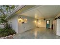 View of a large carport with a blue door, storage and a front yard at 101 Base E Ave # 101 103, Venice, FL 34285