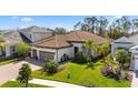 Stunning exterior with lush landscaping, paver driveway, and beautiful tile roof at 11981 Hunters Creek Rd, Venice, FL 34293