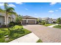 Beautiful home exterior with a paved driveway, a three car garage and manicured landscaping at 11981 Hunters Creek Rd, Venice, FL 34293
