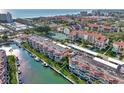 Picturesque aerial view of waterfront condos, boat docks, and beautiful beaches in a vibrant coastal community at 1250 N Portofino Dr # 408Mar, Sarasota, FL 34242