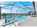 Screened pool and spa offer relaxing lake views, perfect for outdoor enjoyment at 12918 Rainwashed Loop, Parrish, FL 34219