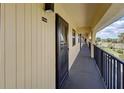 Exterior hallway leading to unit C218 featuring covered walkway and black railings at 14459 River Beach Dr # 218, Port Charlotte, FL 33953