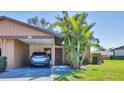 Cozy home with a convenient carport, dark-red front door, and lush palm trees in the front yard at 1709 Curry Trl # 30, Nokomis, FL 34275