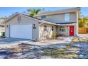 Charming two-story home featuring a two-car garage, a welcoming red front door, and well-kept landscaping at 2219 12Th W Ave, Bradenton, FL 34205