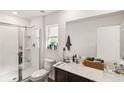 Well-lit bathroom with a glass-enclosed shower, white vanity, and a large mirror at 2721 Burri Ter, North Port, FL 34288