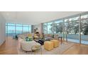 Bright and airy living room with floor-to-ceiling windows offering stunning water views and modern furnishings at 280 Golden Gate Pt # 400, Sarasota, FL 34236
