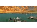 Panoramic waterfront view showcasing a picturesque bridge and boat docks against a dramatic sunset sky at 280 Golden Gate Pt # 400, Sarasota, FL 34236