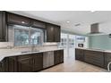 Modern kitchen boasting stainless steel appliances, dark cabinets, and a view to the sun room at 316 Scott Ave, Sarasota, FL 34243