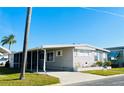 Inviting single-story home with carport and palm trees set against a clear blue sky at 3335 Spanish Oak Ter, Sarasota, FL 34237