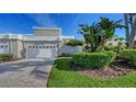 Well-maintained home with manicured lawn and brick paver driveway leading to the attached garage at 3540 Mistletoe Ln, Longboat Key, FL 34228