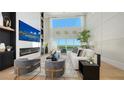 Bright living room features tall ceilings, floor to ceiling windows, fireplace and contemporary furniture at 3540 Mistletoe Ln, Longboat Key, FL 34228
