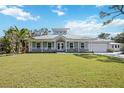 Beautiful single-story home featuring a metal roof, white picket fence and lush green lawn at 3595 Shamrock Dr, Venice, FL 34293