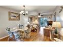 Cozy living and dining area with hardwood floors, chandelier, and sliding glass doors to the balcony at 3698 Lake Bayshore Dr # K-410, Bradenton, FL 34205