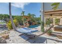 Relaxing backyard with a hammock near a rock waterfall feature and tropical landscaping at 3935 N Shell Rd, Sarasota, FL 34242