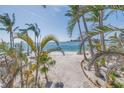 Beautiful beach view framed by tropical palms, with turquoise waters meeting a pristine sandy shore at 3935 N Shell Rd, Sarasota, FL 34242