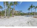 A picturesque beachfront property with white sand and palm trees framing a luxurious home at 3935 N Shell Rd, Sarasota, FL 34242