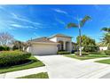 Lovely exterior view with a spacious driveway, attached garage, lush landscaping and a well-maintained lawn at 436 Country Ln, Bradenton, FL 34212