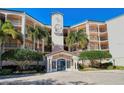 Elegant condo building exterior with lush landscaping, a central tower, and private balconies at 5420 Eagles Point Cir # 106, Sarasota, FL 34231